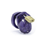 The CBX "Mini-Me" penis cage, shown on a white background. The cage is made of purple plastic with a glittery surface. A brass padlock holds the top closed.