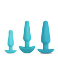 The three plugs from the b-Vibe Anal Training & Education Butt Plug Set in Aqua are shown against a blank background. The plugs are tapered with thin necks and flared, curved bases. They are arranged with the smallest on the left and largest on the right.