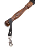A close up image of the Sissoo Rosewood Long Handle Leather Flogger on a white background. Shown is the included leather hanger strap with crab-claw hook attached to the handle of the flogger.