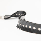 Close up detailed shot of rubber strap with studs and a feathered edge on a white background