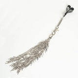 Silver metal feather-shaped flogger on a white background