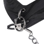 Close-up of the main attachment point of the Velvet Noir collar, showing the nipple clamps beginning to be threaded through it. 