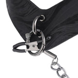 Close-up of the main attachment point of the Velvet Noir collar, showing the nipple clamps beginning to be threaded through it. 