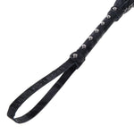 Closeup of the handle of the Velvet Noir Chain Flogger, focused on the wrist strap and the metal studs along the handle. 
