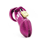 A pink chastity cage with a sparkly surface and a brass Master padlock on the top.