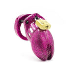 A chastity cage made of pink glittery plastic with a brass padlock on the top.