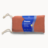 The pouch that the Dame Blanket goes into for storage. Text: Dame Waterproof Blanket for Play. 
