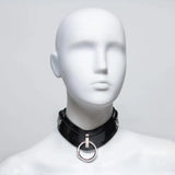 A white mannequin bust with no face, wearing an oval collar made of black rubber with silver-colored hardware. 