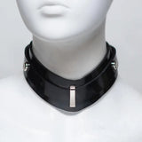 Closeup of a black rubber collar on a mannequin bust, showing the details of the front attachment point. 