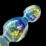 The tip of an anal bead toy made of transparent PVC, shown against a black background. The inside is filled with purple, blue, and yellow sparkles, with an irridescent sheen on the outer surface. 