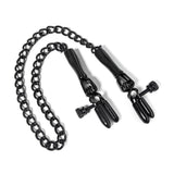 A pair of black metal nipple clamps with adjustment screws and connected by a length of black chain on a white background. 