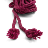 The knotted ends of the wine colored jute waxed rope are shown on a white background. 