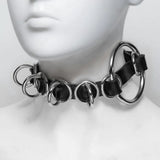 Closeup of a mannequin's neck, showing the rubber collar woven through several metal O-Rings. 