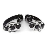  Two rubber wrist cuffs on a white background. The slim rubber bands are interwoven with a number of metal O-Rings of varying sizes. 