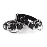Two rubber wrist cuffs, one resting on top of the other to display the side. The rubber is interwoven with metal O-Rings for decoration. 