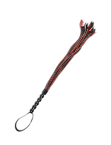 The Saffron Braided Flogger is shown against a blank background. The falls of the flogger are made of intertwined pieces of red and black faux-leather. The handle of the flogger is bubble textured, and is black and shiny, with a wrist loop at the end.