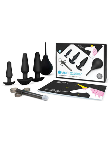 The contents of the b-Vibe Anal Training & Education Butt Plug Set in Black are shown against a blank background. The box is shown along with the 3 plugs, a black enema bulb and lube shooter, and a guide to anal play.