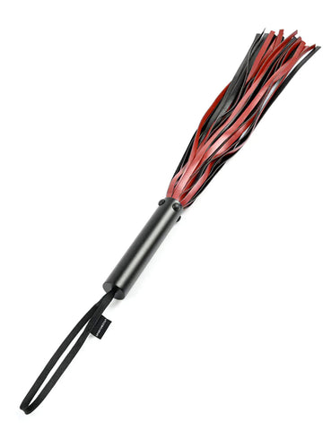 The Saffron Flogger is shown against a blank background. The falls of the flogger are red and black faux-leather. The handle of the flogger is smooth and black, and has a wrist loop attached to the end.