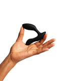 The We-Vibe Vector+ Vibrating Prostate Massager is shown with a hand holding it on a white background.